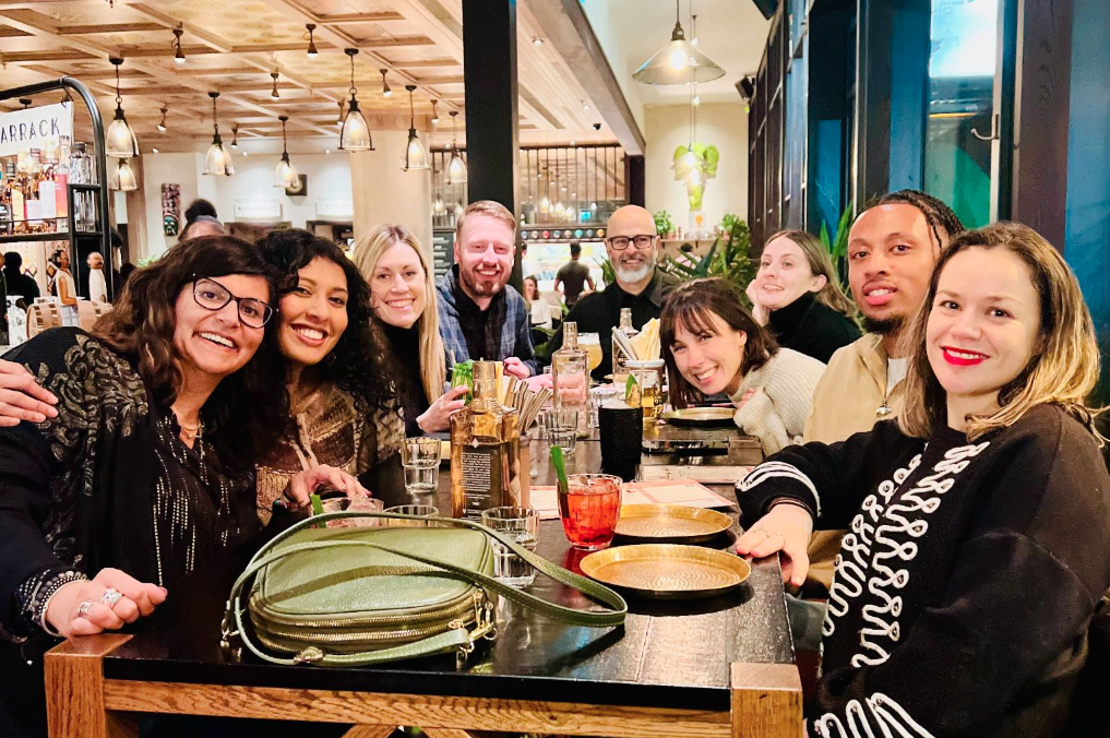 Nine members of the UK team sitting together at a restaurant