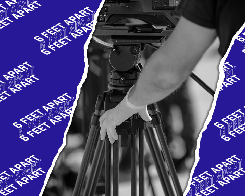 Camera person adjusting equipment with gloves on.