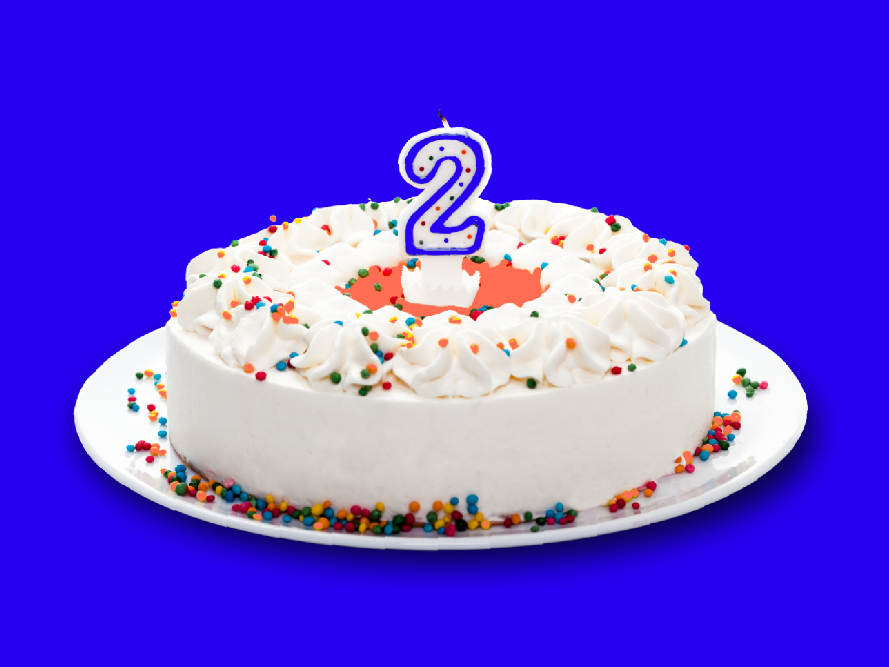 white birthday cake with sprinkles and a #2 candle in the middle. bright blue background