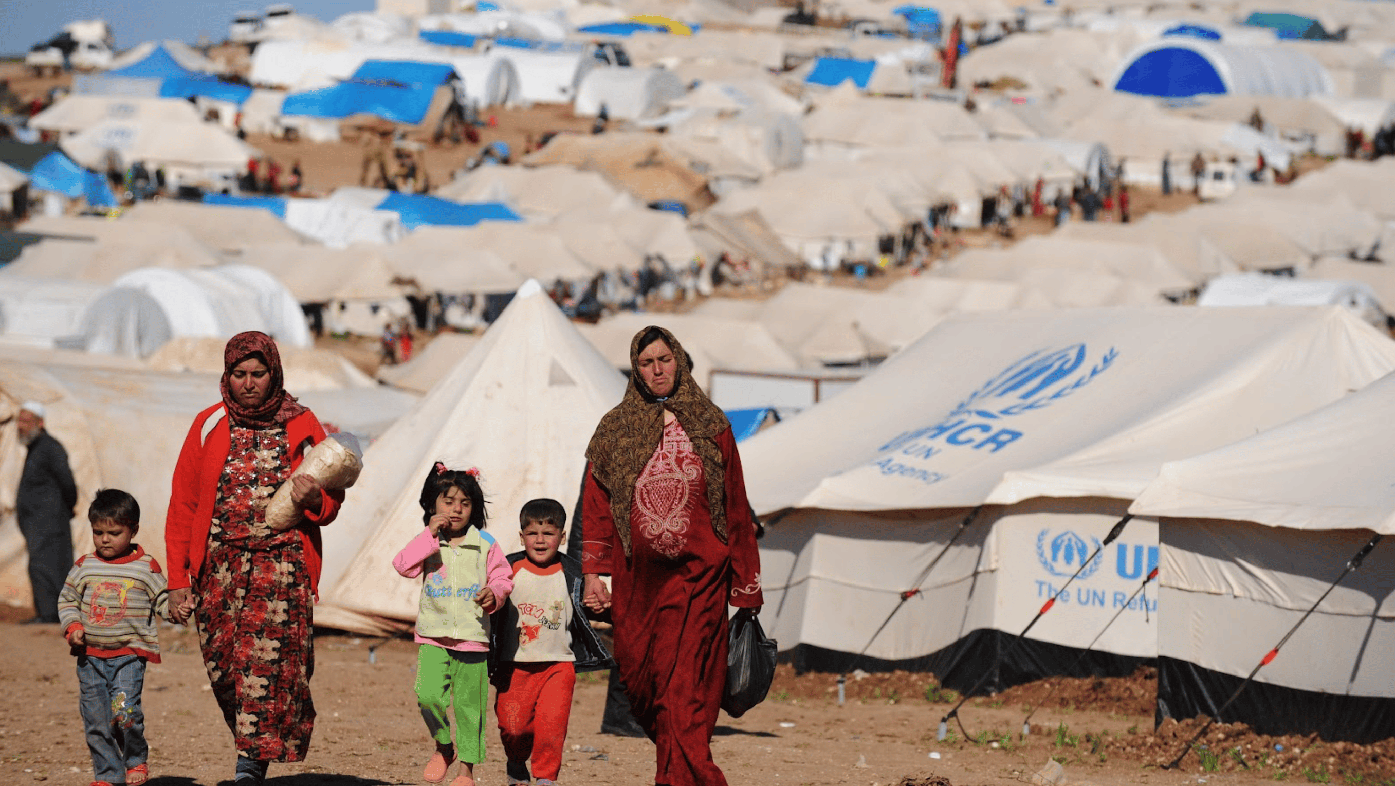 Refugee women (2) and children (3) leaving a UNHCR base camp