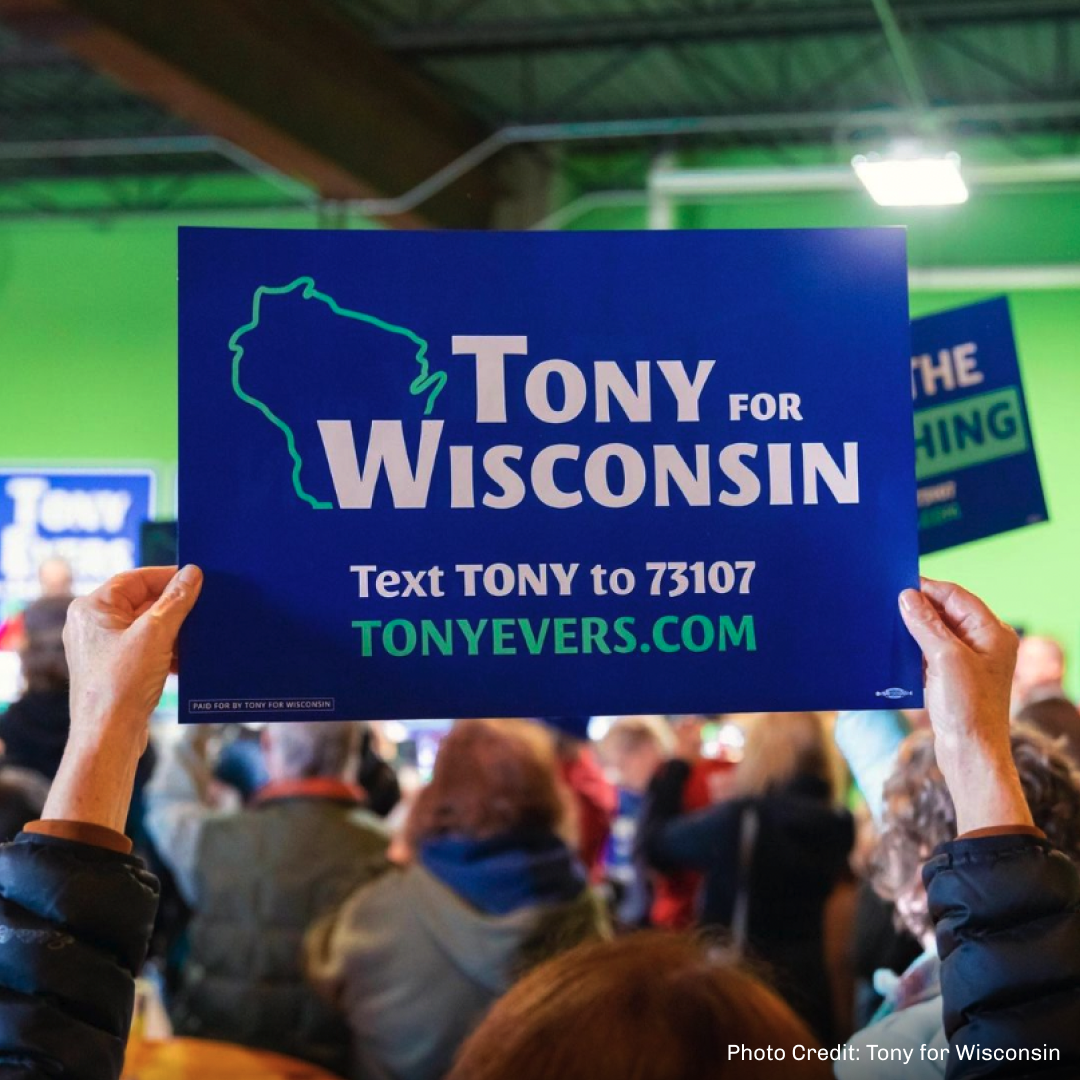 Gov. Tony Evers sign at an event.