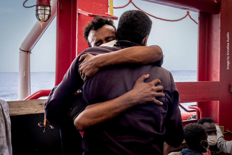 Photograph by Annalisa Ausilio of two people hugging onboard a rescue boat